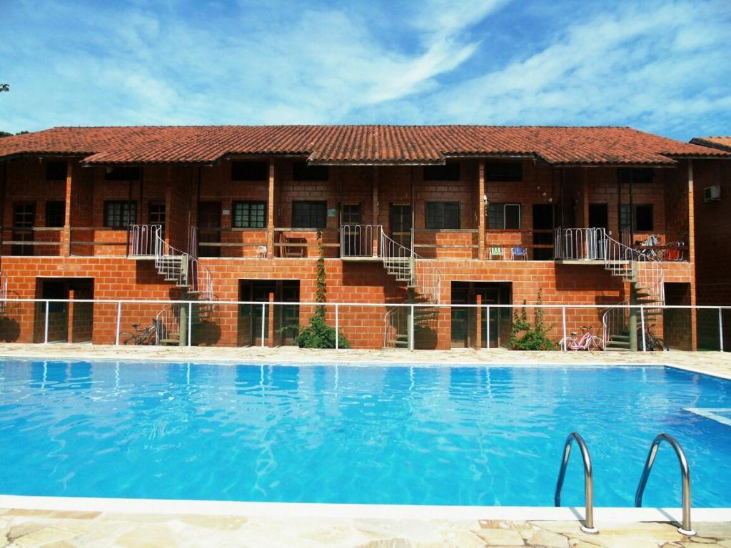 Piscina do condomínio em frente aos prédios com telhado de telha