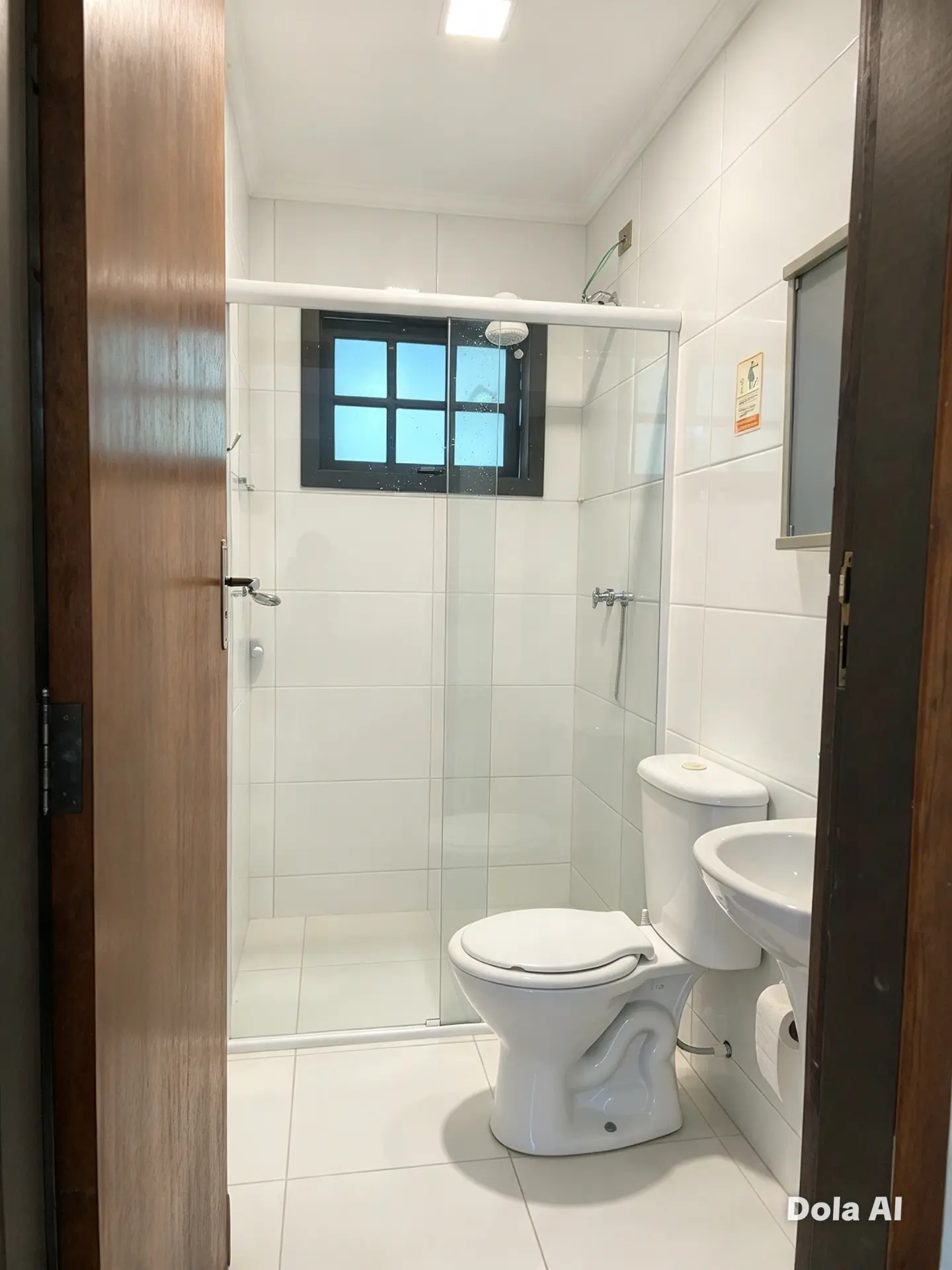 Banheiro do apartamento com box de vidro, vaso sanitário e pia
